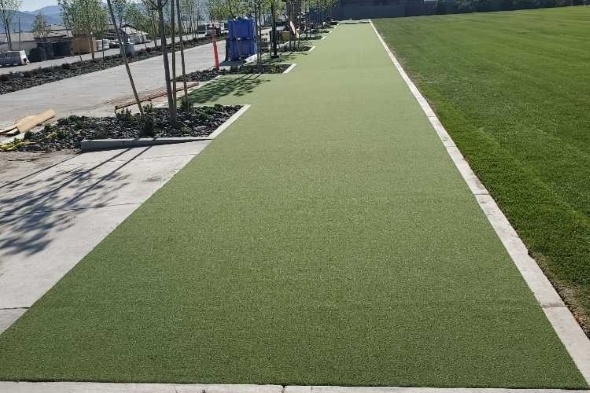 Metro New York Outdoor tee line consisting of one continuous green synthetic grass strip surrounded by trees